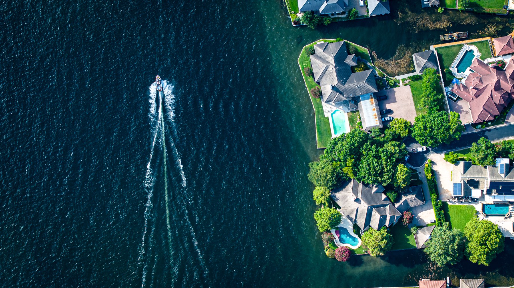 Waterfront homes and a boat photographed from above